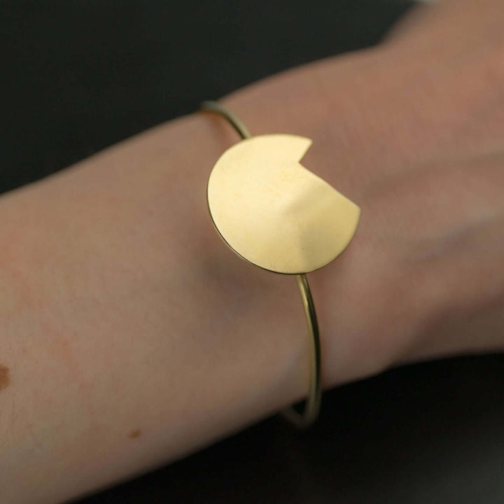 A woman's wrist showing a Bold Lines Jewellery designed Abstract gold Balance bracelet.
