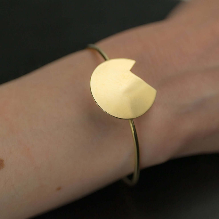 A woman's wrist showing a Bold Lines Jewellery designed Abstract gold Balance bracelet.