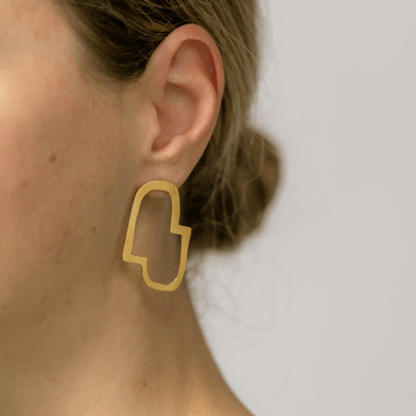 Connection II abstract earrings designed by Bold Lines Jewellery worn on a woman with a bun.