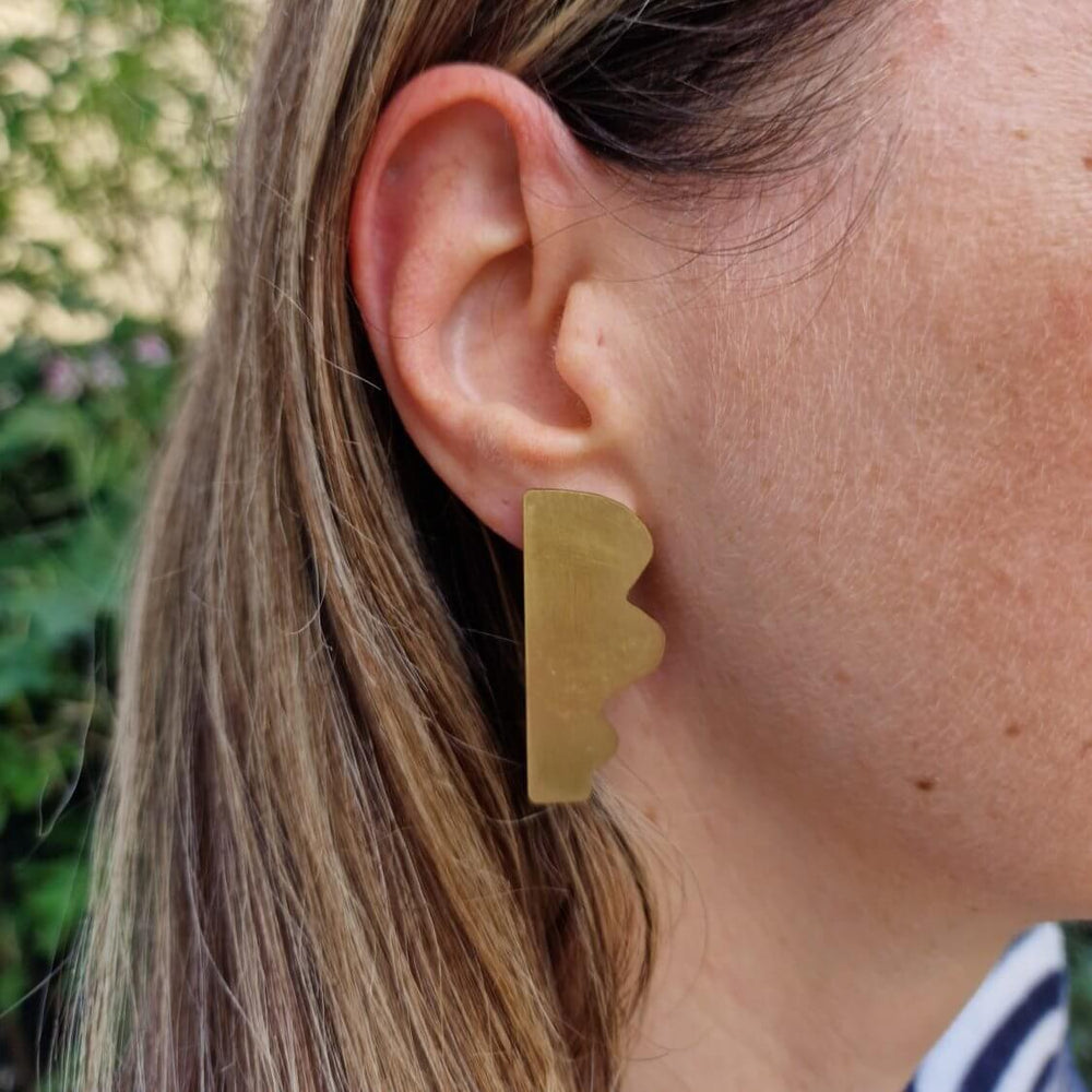 Dream I statement earrings by Bold Lines Jewellery are shown on a woman's ear with trees in the background.