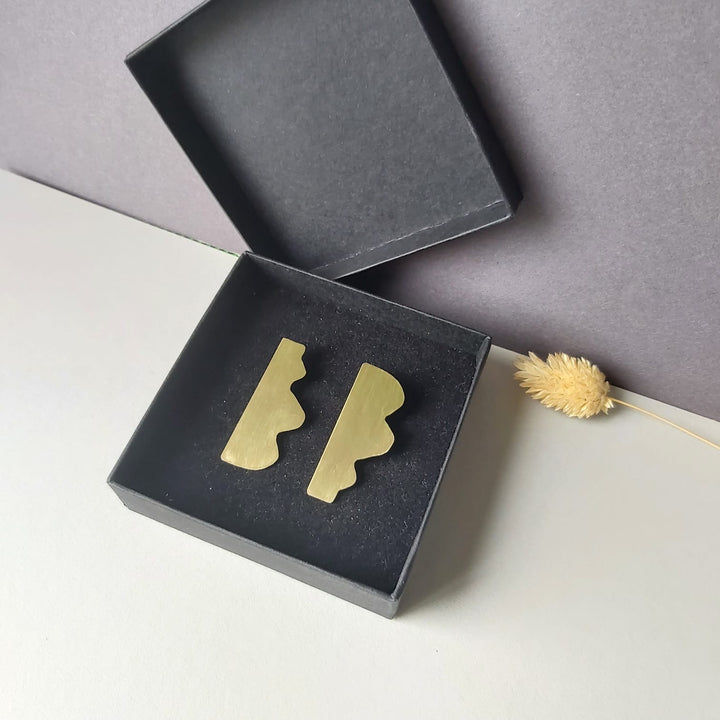 Dream I geometric earrings designed by Bold Lines Jewellery are shown in a black jewellery box in front of a grey and white background.