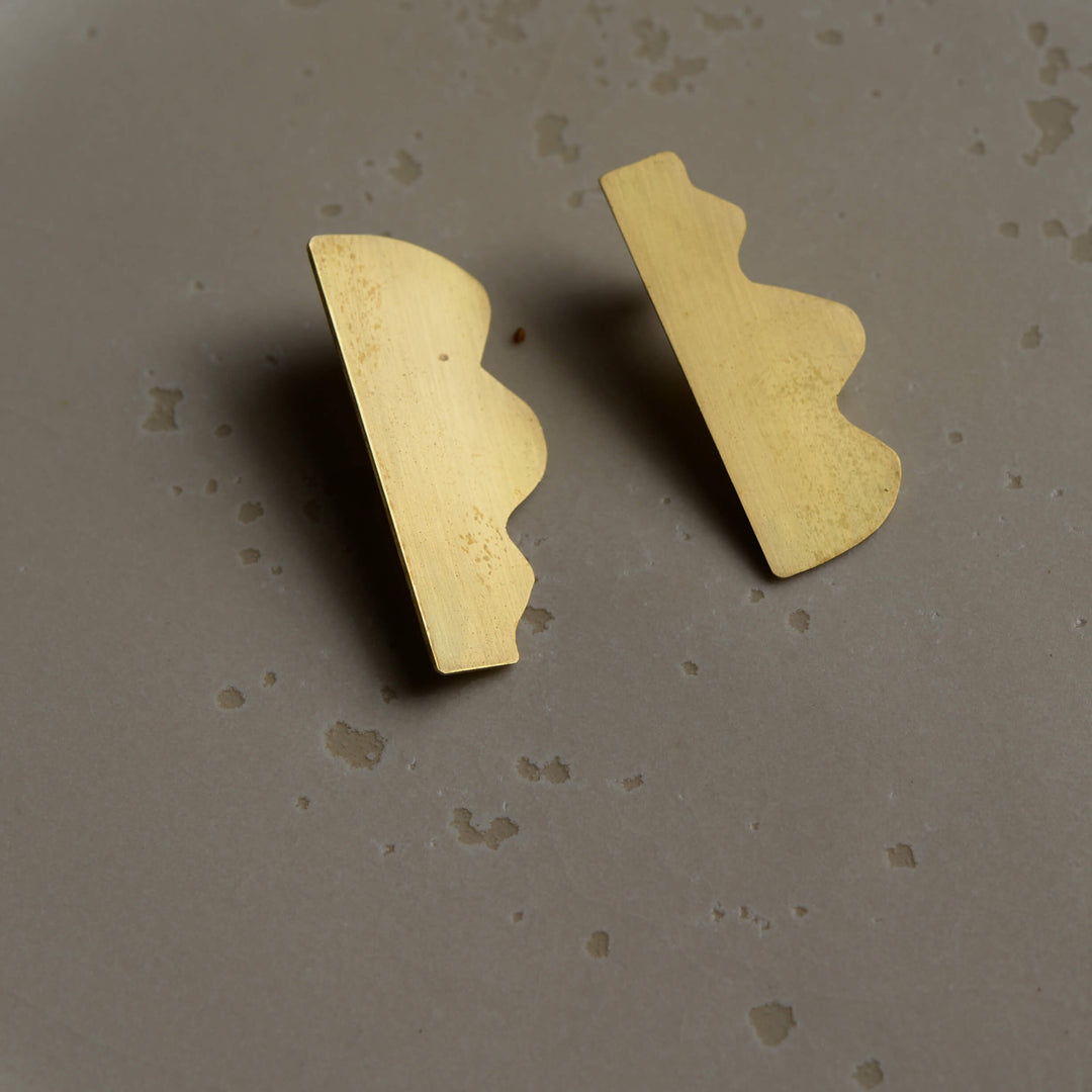 Abstract stud Dream I earrings by Bold Lines Jewellery shown on a ceramic plate.