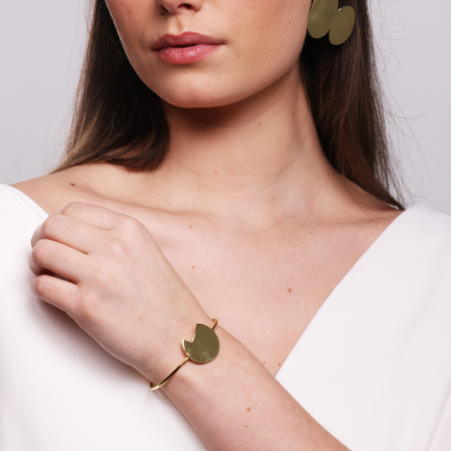 Model wearing a white dress and the Bold Lines Balance gold bracelet