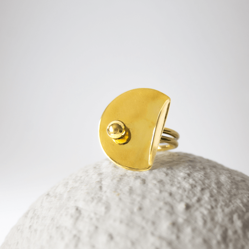 Bold Lines jewellery Gold ring with a small gemstone ball on a textured white surface