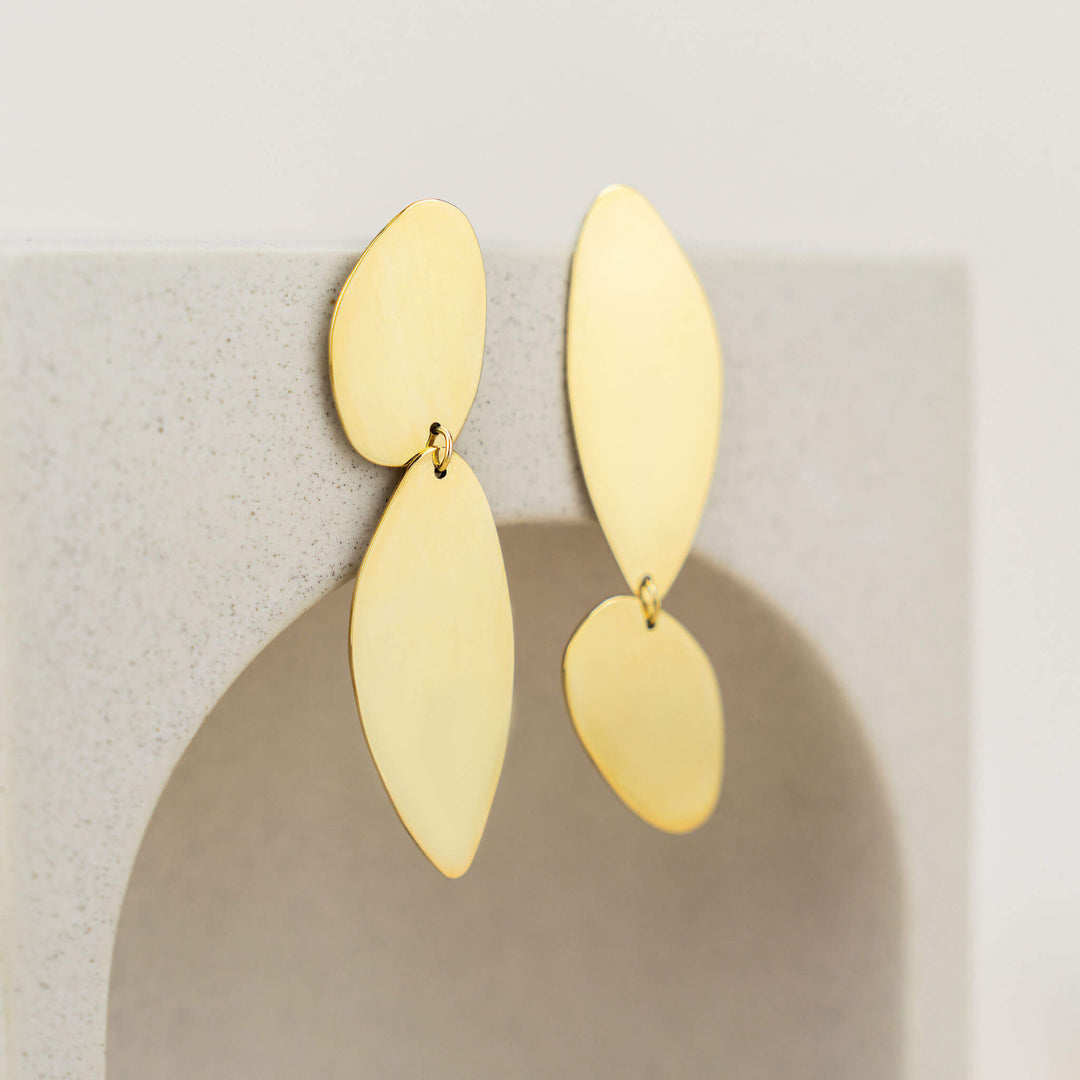  Fluidity earrings designed by Bold Lines Jewellery hanging on a geometric circular display