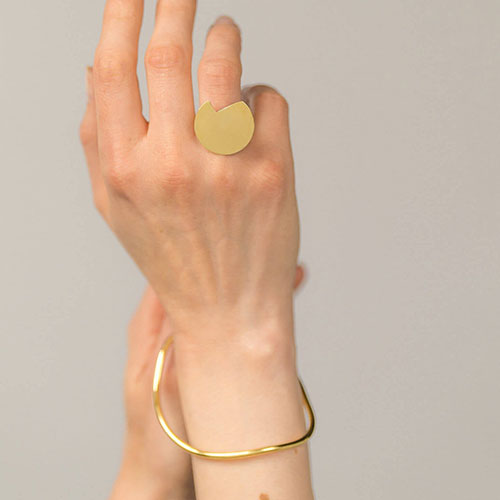 A hand showing the Abstract Balance ring paired with the imperfection bangle.