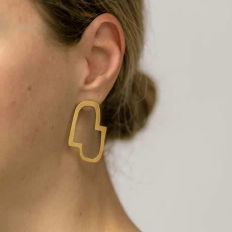 Connection II abstract earrings designed by Bold Lines Jewellery worn on a woman with a bun