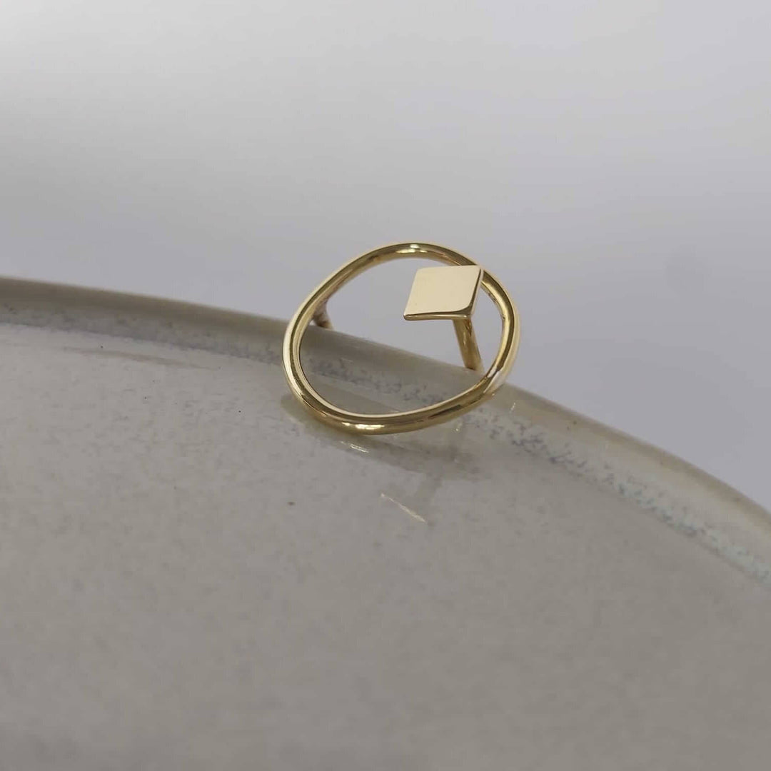 The Bold Lines jewellery Imperfection organic square ring  displayed on a light grey ceramic plate, side view.