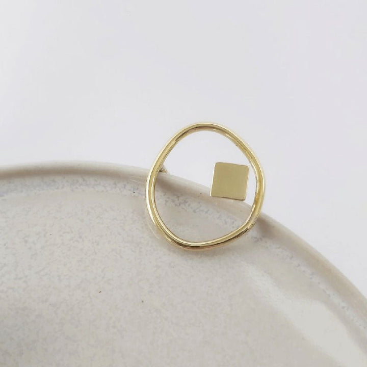 Shot focused on the Imperfection organic and square ring by  Bold Balance displayed on a light grey ceramic plate
