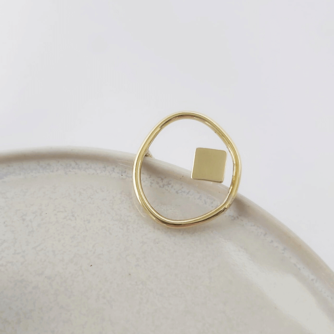 Shot focused on the Imperfection organic and square ring by  Bold Balance displayed on a light grey ceramic plate