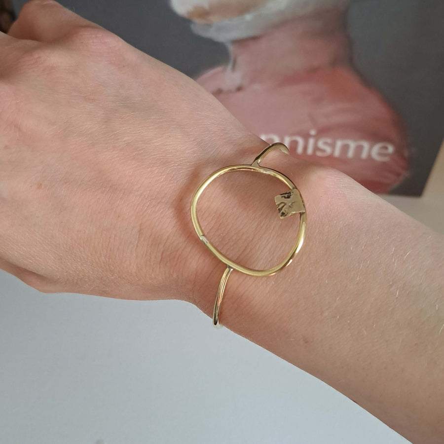 Bold Lines Jewellery composition geometric bracelet worn on a woman's wrist in front of a book