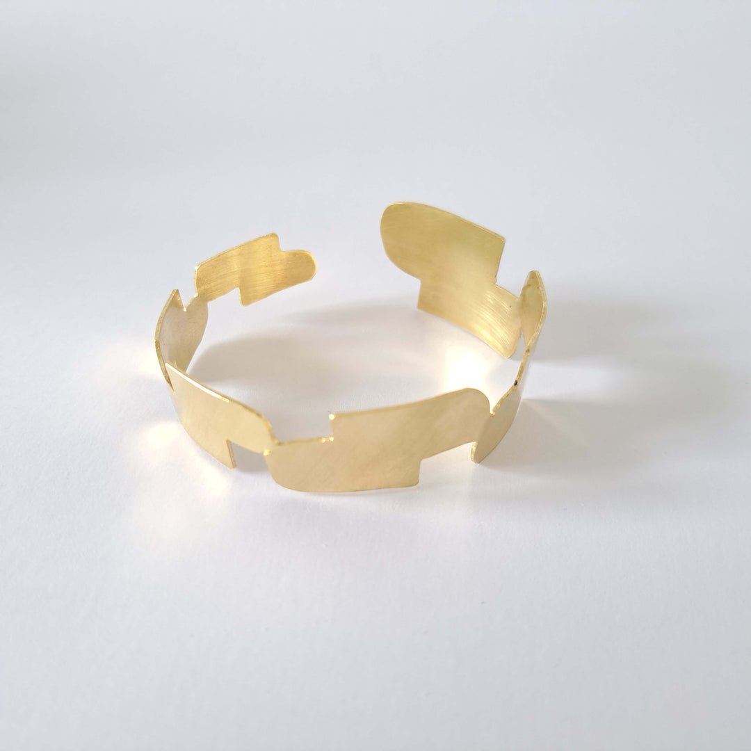 Bold Lines jewellery gold minimal Connection bangle shown on a light grey background. 