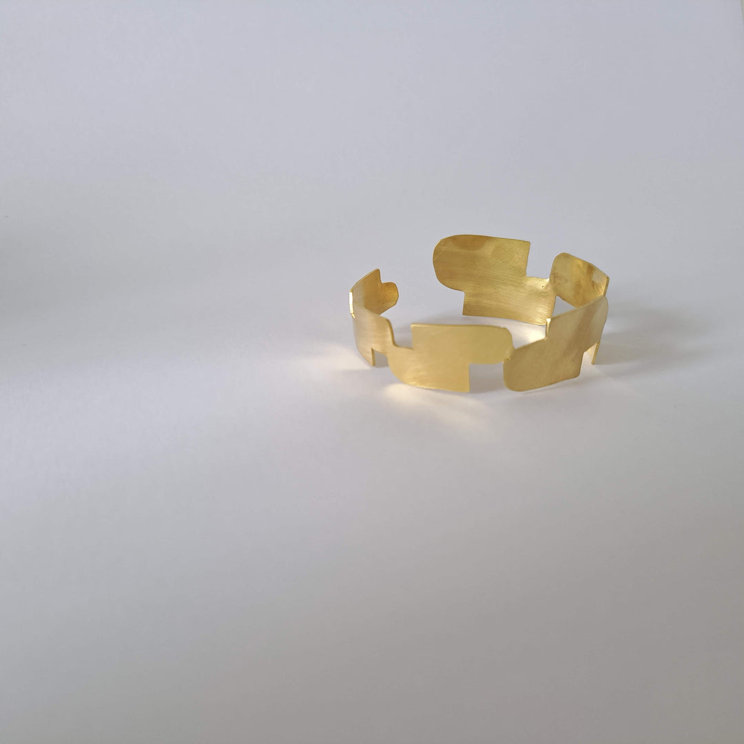 Bold Lines jewellery gold statement geometric Connection bangle shown on a light grey background