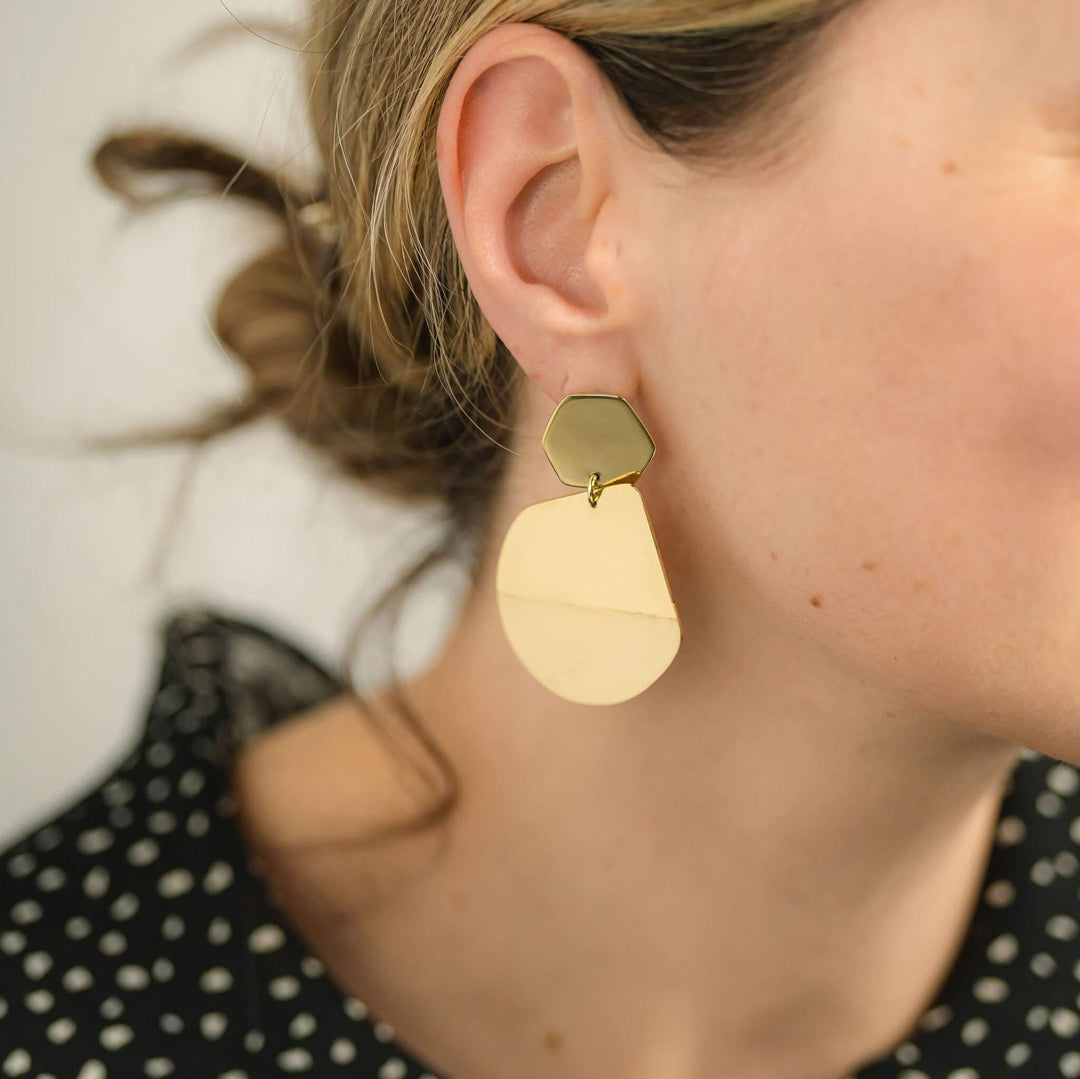 Reflection statement geometric earrings by Bold Lines Jewellery, shown on a woman's ear wearing a black and white polka dots top