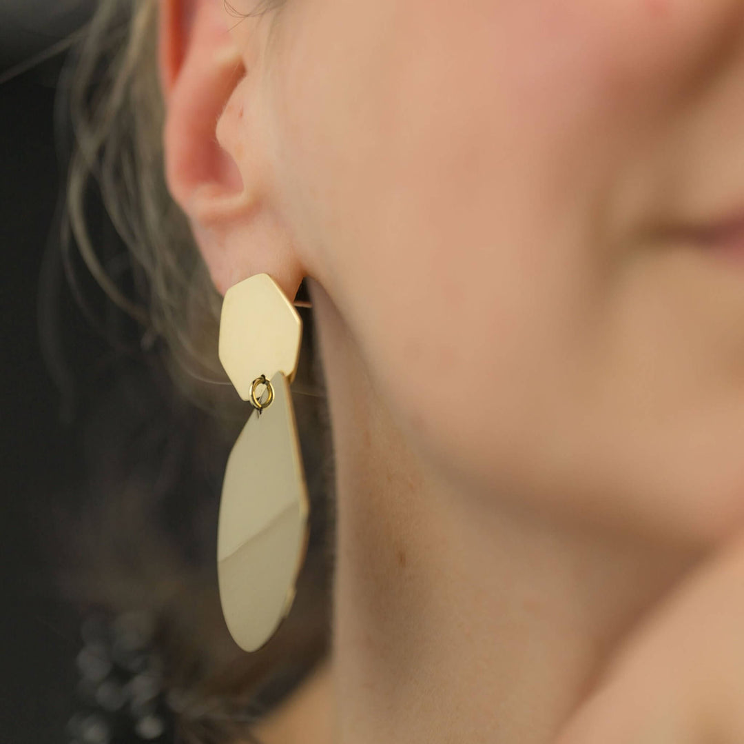 Reflection statement geometric earrings by Bold Lines Jewellery, shown in a side view on a woman's ear.