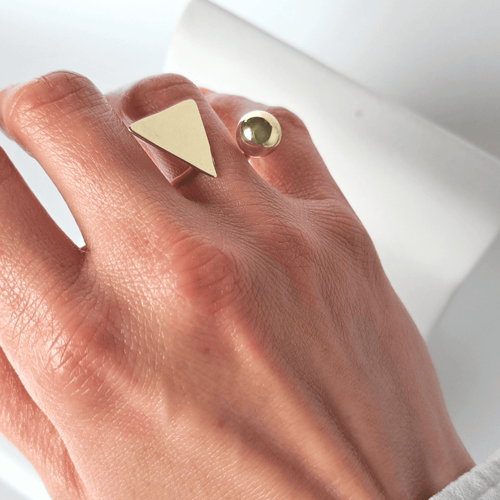 Soline gold ring designed by Bold Lines Jewellery, triangle and ball, on a hand wedding finger