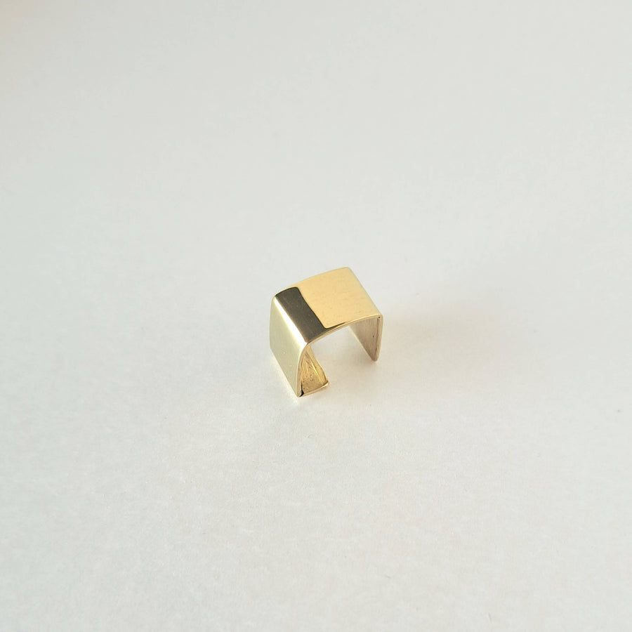 Gold brass earcuff on a light gray background by bold Lines Jewellery 