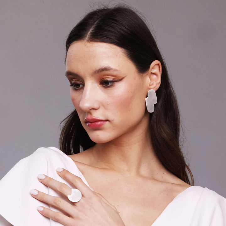 woman wearing bold lines jewellery sterling silver abstract earrings and a white top