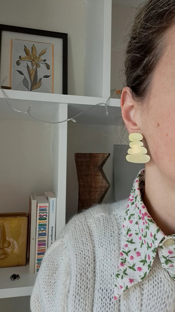 A woman wearing an organic shape earring.