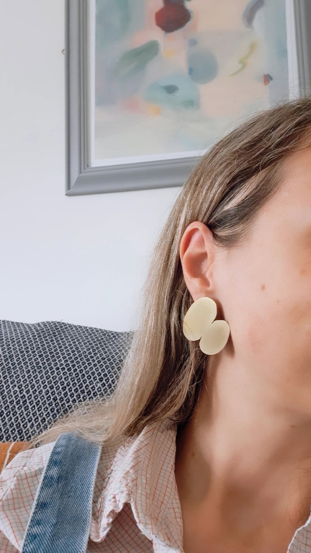 A woman wearing a gold earring.