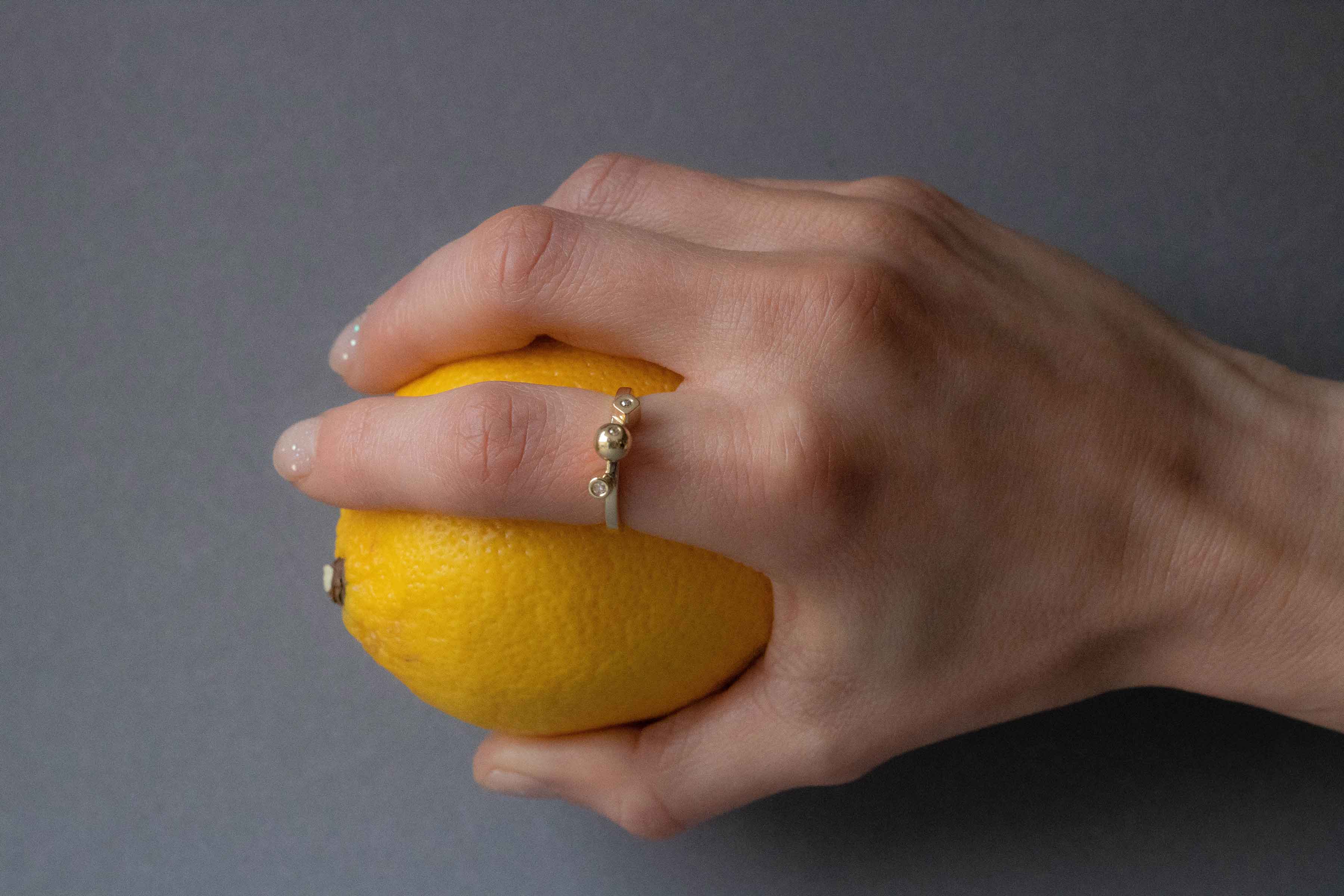 Unique Yellow Gold ring with diamonds holding a lemon