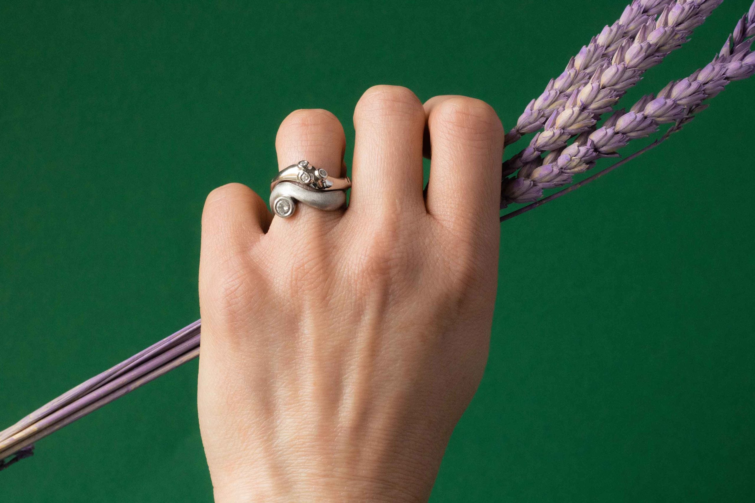 A hand with a ring holding a bunch of lavender.