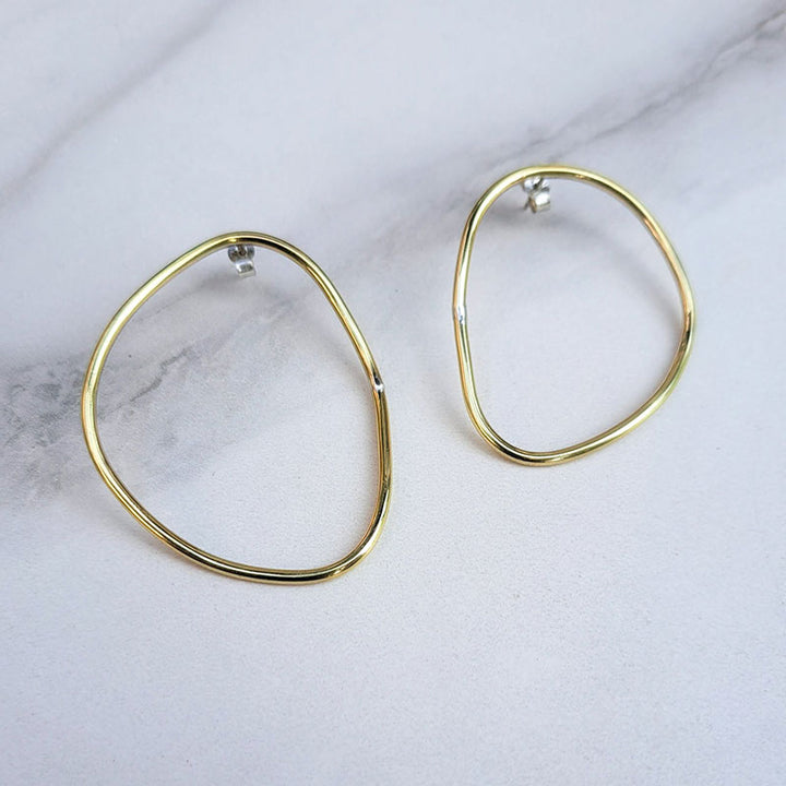 Imperfection organic hoop earrings with sterling silver backs designed by Bold Lines jewellery shown on a light grey background