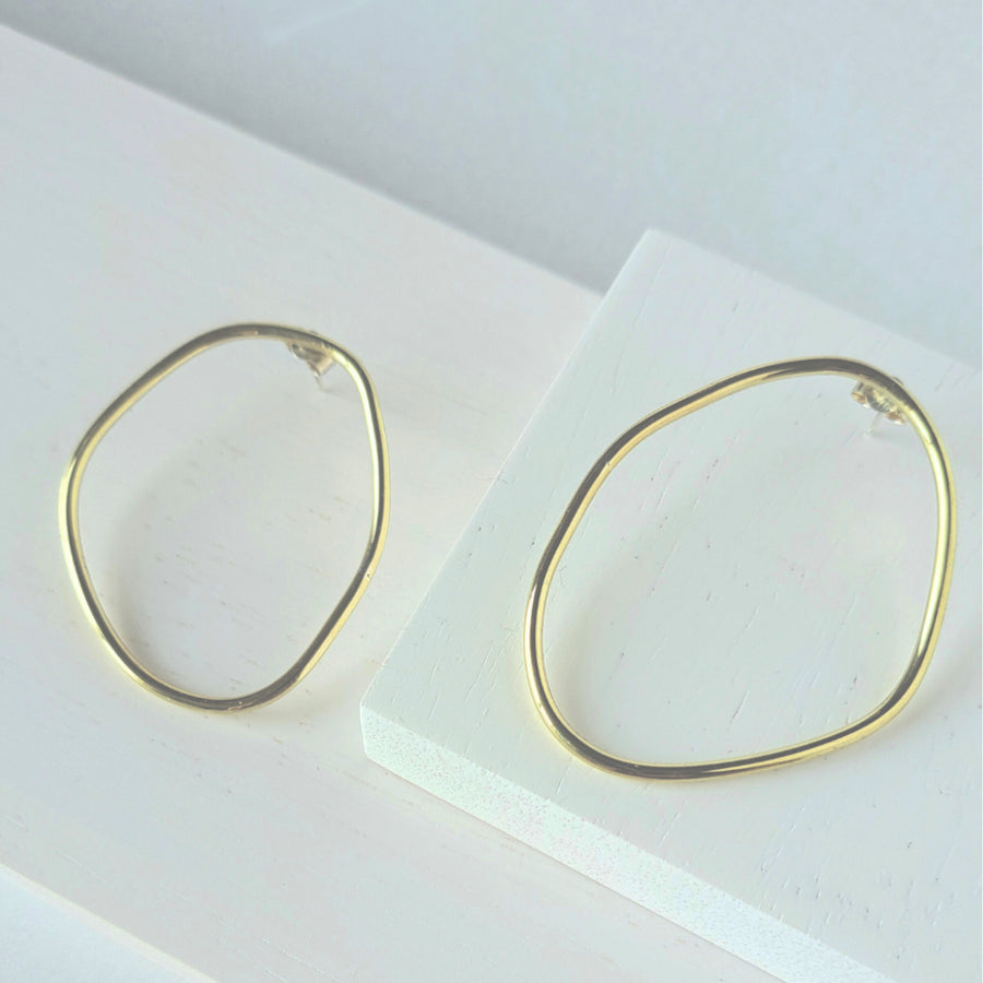 Gold hoop earrings on a white surface