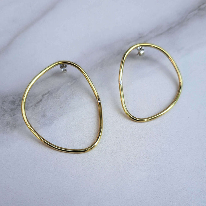 Imperfection organic hoops earrings with sterling silver backs designed by Bold lines jewellery shown on a light grey background