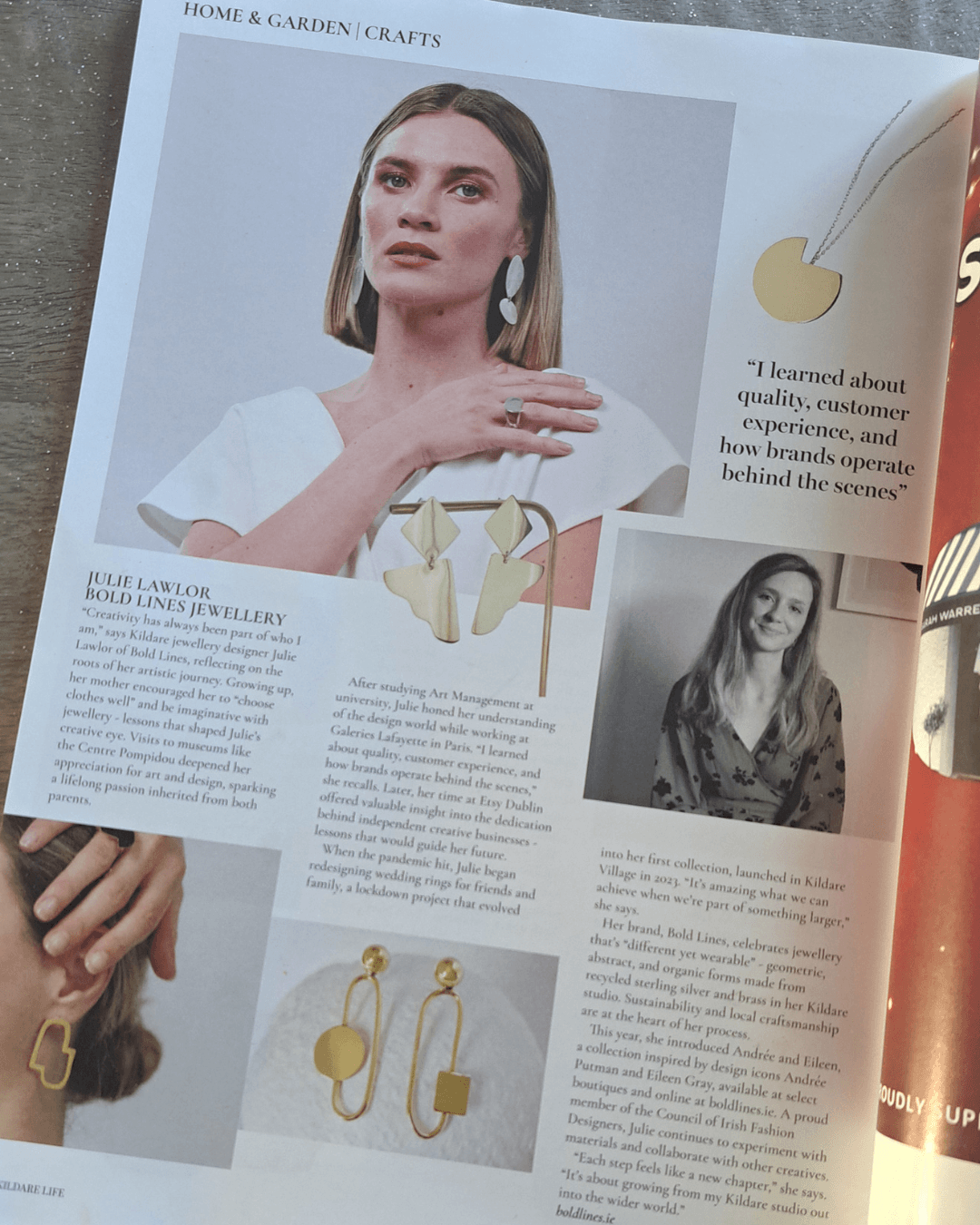 Open magazine featuring a woman wearing Bold Lines Jewellery gold earrings with text article about jewelry brand Julie Lawlor.
