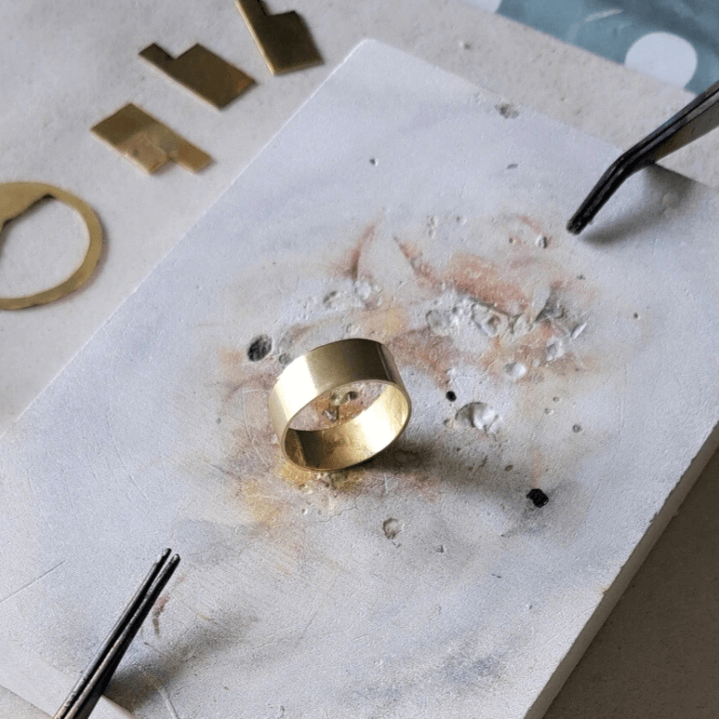 Montagne gold ring shown on a soldering block.