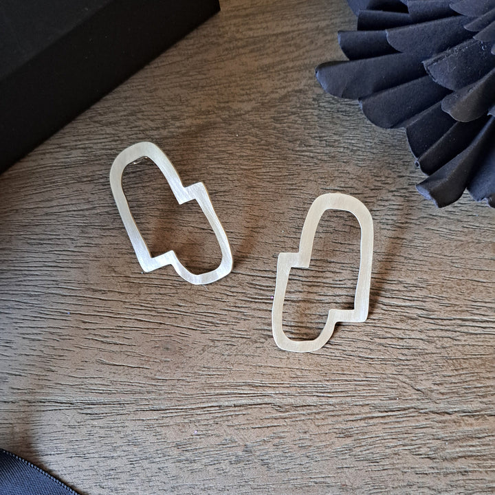 Sterling silver minimal earrings by Bold Lines Jewellery  on a wooden surface.