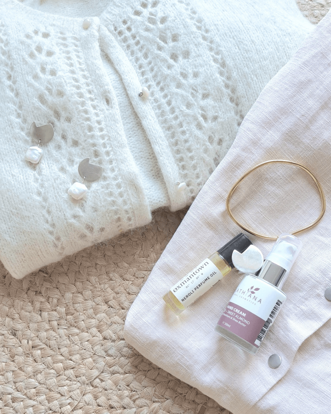 photo showing a Bold Lines Jewellery earrings, ring and Imperfection gold bangle paired with french cardigan and blouse and wellness products.