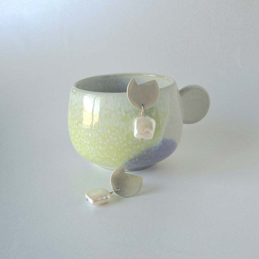 Ceramic cup with decorative elements on a light gray background