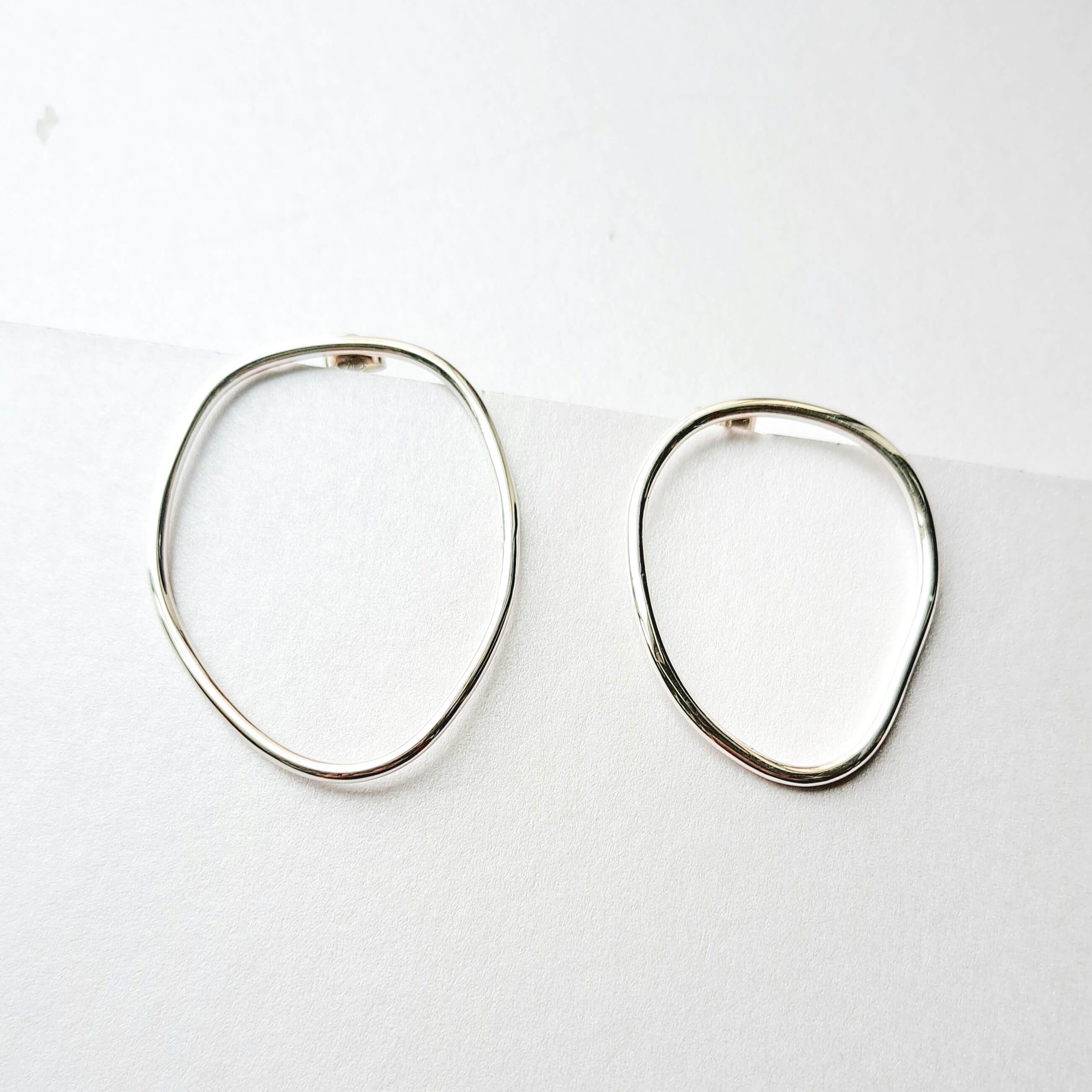 Pair of silver hoop earrings on a white background