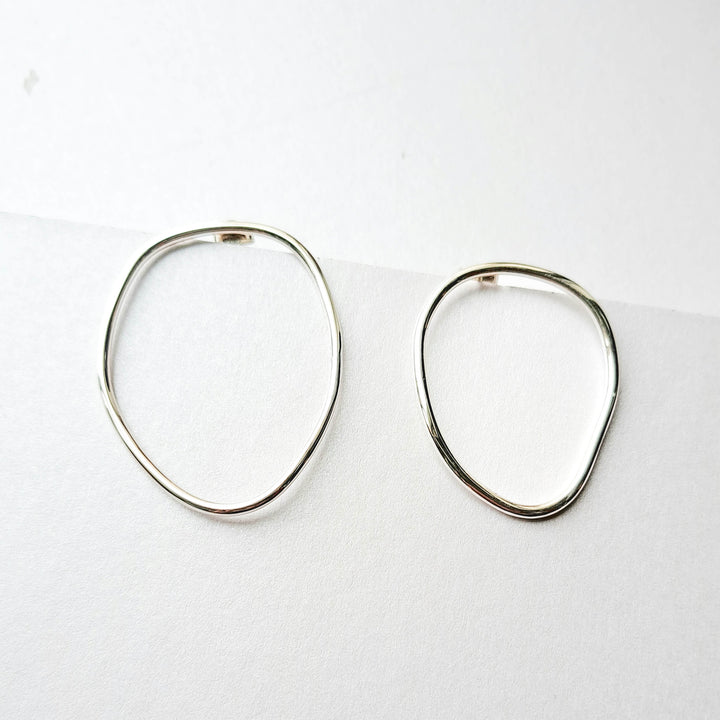 Pair of silver hoop earrings on a white background