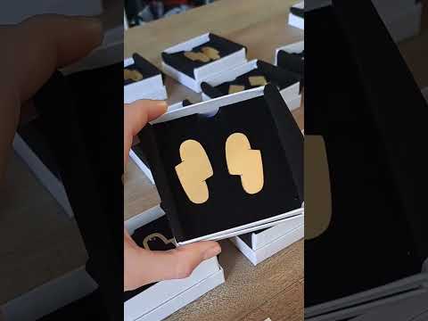 Video of the Connection I gold abstract earrings shown in their white box with a black insert.