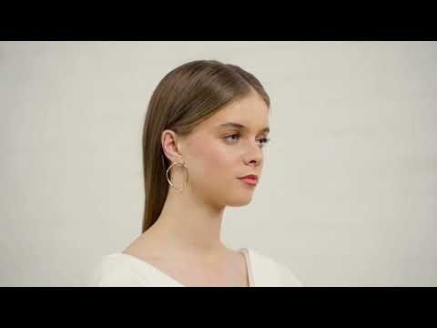 Model with white top wearing the organic gold Bold Lines jewellery hoops earrings, Soline ring and Composition bracelet