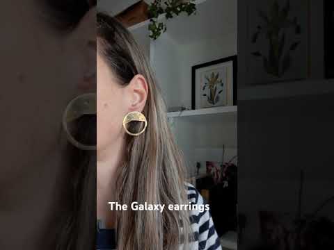 Video showing the Gold circular galaxy earrings worn on a woman wearing a stripes jumper.