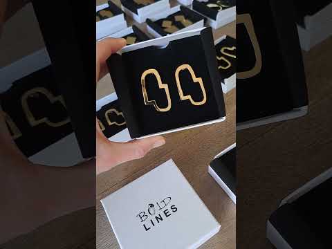 Connection II gold abstract earrings shown in their black and white jewellery box