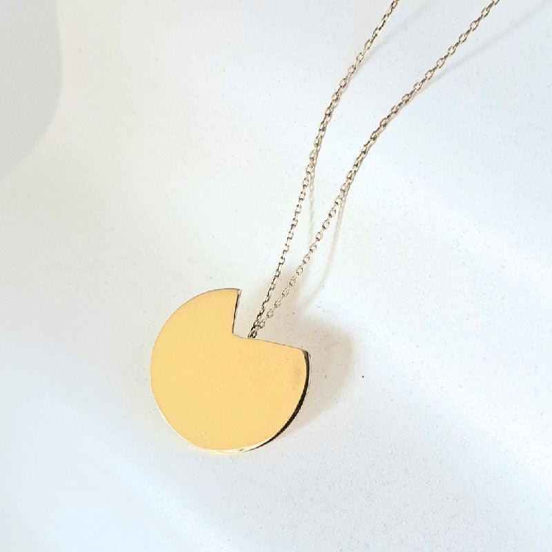 The Gold Balance Abstract Necklace against a white background